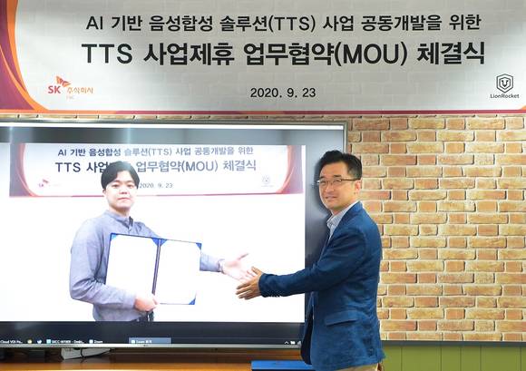 ▲이석진 SK㈜ C&C 채널&마케팅그룹장과 정승환 라이언로켓 대표(화면)가 화상회의로 인공지능(AI) 텍스트 음성변환(TTS) 사업 협력 협약을 체결한 뒤 기념촬영을 하고 있다. / 사진=SK㈜ C&C