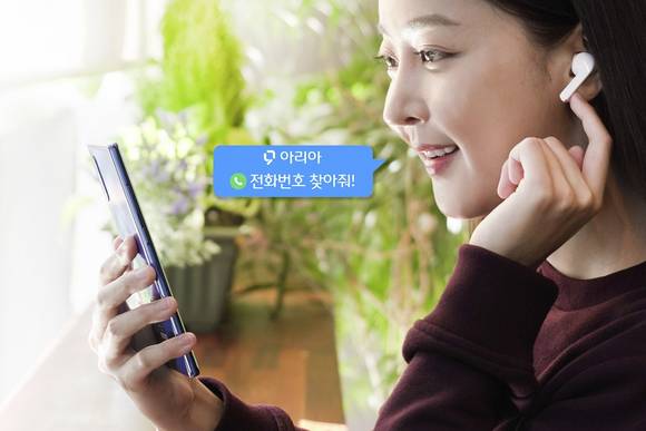 ▲SK텔레콤은 자사의 인공지능(AI) 서비스 ‘누구(NUGU)’를 기반으로 한 AI 비서 서비스 ‘T전화x누구’를 출시한다고 12일 밝혔다. 모델이 ‘누구 버즈’를 통해 ‘T전화x누구’의 검색 기능을 사용하고 있다. / 사진=SK텔레콤