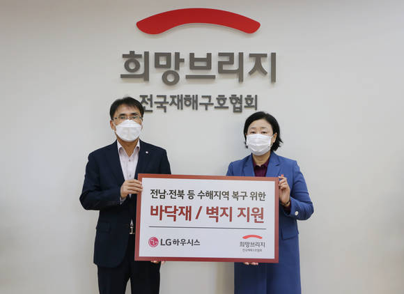 ▲박귀봉 LG하우시스 장식재사업부장(왼쪽)과 김정희 희망브리지 전국재해구호협회 사무총장이 수해복구자재 전달식 후 기념촬영을 하고 있다. / 사진=LG하우시스