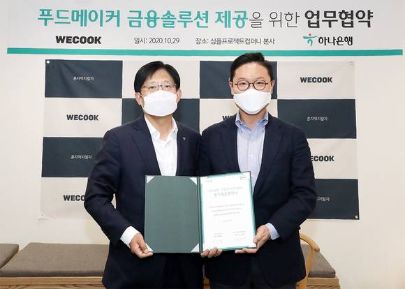 ▲강성묵 하나은행 중앙영업2그룹 부행장(왼쪽)과 심플프로젝트컴퍼니 김기웅 대표가 협약을 체결하고 기념촬영을 하고 있다. / 사진=하나은행