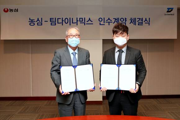 ▲박준 농심 대표이사(왼쪽)와 오지환 팀다이나믹스 대표이사가 인수계약 체결식에서 기념촬영을 하고 있다. / 사진=농심