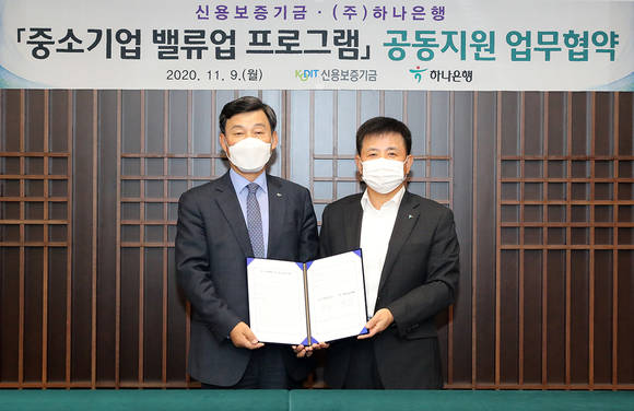 ▲박승오 하나은행 여신그룹장(오른쪽)과 최창석 신용보증기금 이사가 협약을 체결하고 기념촬영을 하고 있다. / 사진=하나은행