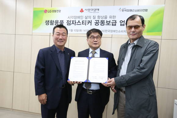▲박헌영 LG생활건강 대외협력부문 전무(왼쪽), 이병돈 한국장애인소비자연합 대표, 김병철 한국장애인소비자연합 감사가 생활용품 점자스티커 보급 등을 위한 업무협약 체결 기념사진을 찍고 있다. / 사진=LG생활건강