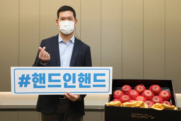 ▲허윤홍 GS건설 신사업부문 대표가 '핸드 인 핸드' 소셜 릴레이 캠페인에 동참해 기념촬영을 하고 있다. 허 대표는 영농조합법인에서 구매한 사과를 '꿈과 희망의 공부방' 가정과 아동들에게 전달했다 / 사진=GS건설