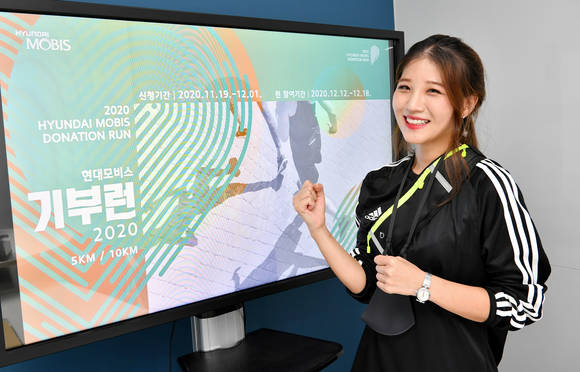 ▲현대모비스가 언택트 마라톤을 진행한다. 마라톤에 참여하는 직원이 언택트 기부런에서 제공하는 기념품을 착용하고 사진을 촬영하고 있다 / 사진=현대모비스
