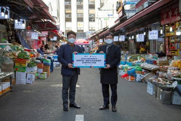 ▲이근주 한국간편결제진흥원장(오른쪽)과 문남엽 남대문시장상인회장이 ‘모바일 온누리상품권 이용 활성화’ 업무협약을 체결한 뒤 기념촬영을 하고 있다. / 사진=한국간편결제진흥원