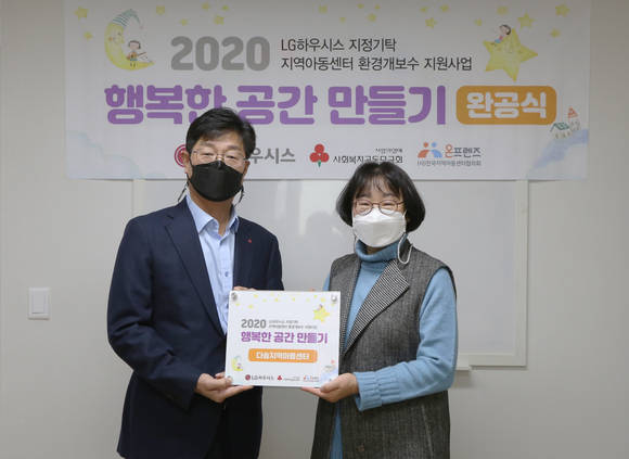 ▲경기도 광명시에 위치한 다솜지역아동센터에서 이동주 LG하우시스 홍보·대외협력담당 상무(왼쪽)가 김정숙 다솜지역아동센터 시설장에게 개보수 공사 완료를 기념해 현판을 전달하고 있다 / 사진=LG하우시스