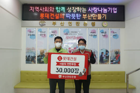 ▲지승렬 롯데건설 상무(사진 오른쪽)와 강정철 부산연탄은행 대표가 기념촬영을 하고 있다 / 사진=롯데건설