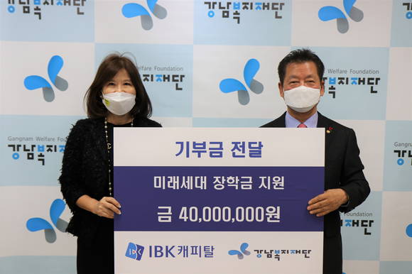 ▲최현숙 IBK캐피탈 대표(왼쪽)가 이의신 강남복지재단 이사장에게 장학금을 전달하고 기념사진 촬영을 하고 있다. / 사진=IBK캐피탈