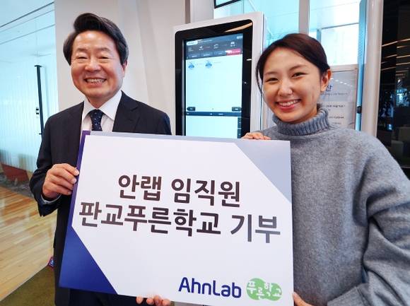 ▲강석균 안랩 CEO(왼쪽)가 지역아동센터 '판교푸른학교'에 기부금을 전달하고 안랩 직원과 기념촬영을 하고 있다. / 사진=안랩