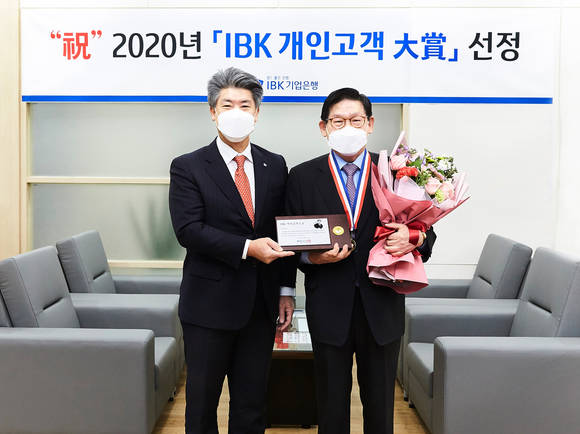 ▲지난 30일 기업은행 강남지역본부 회의실에서 윤종원 IBK기업은행장(왼쪽)과 이홍근 고객이 감사패를 들고 기념촬영을 하는 모습 / 사진=IBK기업은행