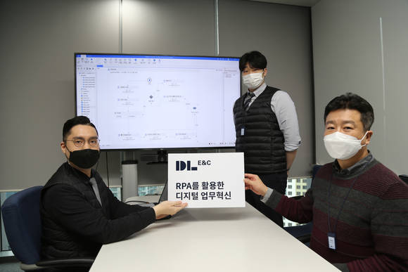 ▲DL이앤씨 직원들이 RPA 업무 자동화 도입을 설명하는 피켓카드를 들고 있다 / 사진=DL이앤씨
