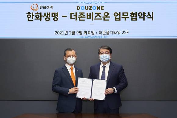 ▲김용우 더존비즈온 대표(오른쪽)와 여승주 한화생명보험 대표가 사업 협력 및 공동 마케팅 추진을 위한 업무협약서를 교환하고 있다. / 사진=더존비즈온