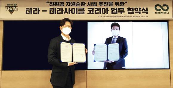 ▲오성택 하이트진로 상무와 이지훈 테라사이클 한국지사 본부장이 업무협약 기념사진을 찍고 있다. / 사진=하이트진로