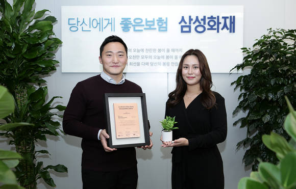 ▲삼성화재 직원들이 다우존스 월드지수 편입인증서를 들고 ESG위원회 설립을 축하하고 있다. / 사진=삼성화재