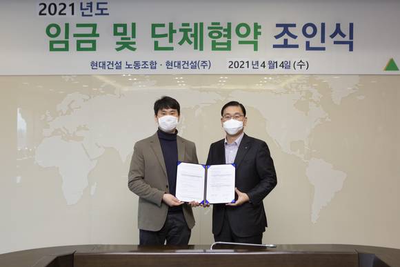 ▲윤영준 현대건설 대표이사(오른쪽)과 김준효 노조위원장이 14일 열린 '2021년도 임금 및 단체협약 체결식'에서 협약서에 서명한 뒤 기념사진을 찍고 있다 / 사진=현대건설