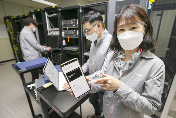 ▲KT는 스마트폰 앱을 통해 양자암호통신 기술을 구현할 수 있는 ‘양자 하이브리드’ 기술을 개발했다고 20일 밝혔다. 대전 KT대덕제2연구센터에서 연구원들이 양자 하이브리드 기술을 시연하고 있다. / 사진=KT