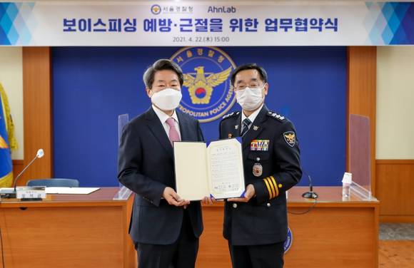 ▲강석균 안랩 대표(왼쪽)와 장하연 서울경찰청장이 22일 서울경찰청에서 보이스피싱 예방 및 근절을 위한 업무협약을 체결한 뒤 기념촬영을 하고 있다. / 사진=안랩
