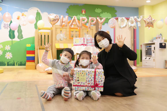 ▲우리은행으로부터 어린이날을 맞아 선물을 전달받은 직장어린이집 어린이들과 교사가 기념촬영을 하고 있다. / 사진=우리은행