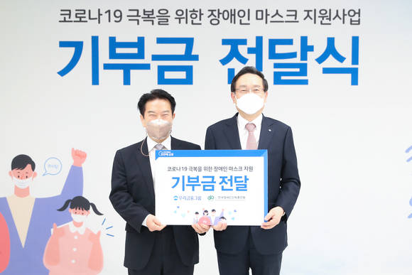 ▲손태승 우리금융그룹 회장(오른쪽)과 최공열 한국장애인단체총연맹 상임대표가 4일 방역 취약계층 마스크 지원을 위한 기부금 전달식에서 기념촬영을 하고 있다. / 사진=우리금융그룹