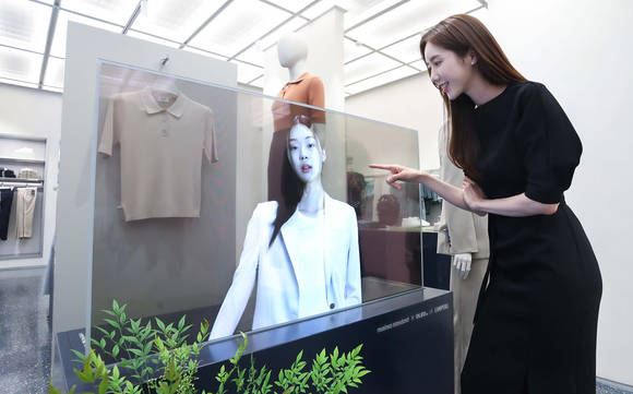 ▲서울 마포구에 위치한 ‘무신사 스탠다드 홍대’에서 LG디스플레이 모델이 투명 OLED로 신상 의류를 확인하고 있다. / 사진=LG디스플레이