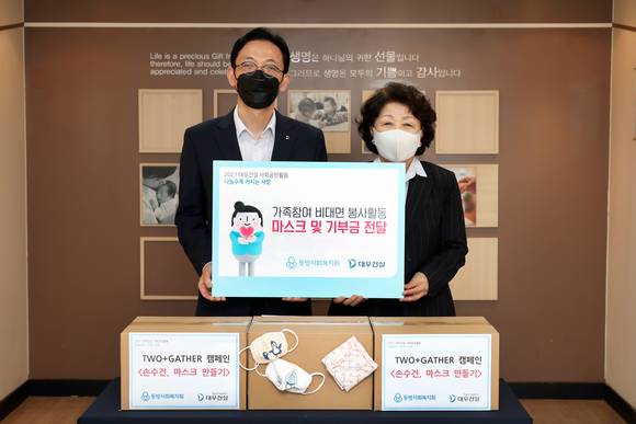 ▲(왼쪽부터) 강기남 대우건설 관리지원실장과 김진숙 동방사회복지회 회장 마스크와 기부금 전달식에서 기념촬영을 하고 있다 / 사진=대우건설