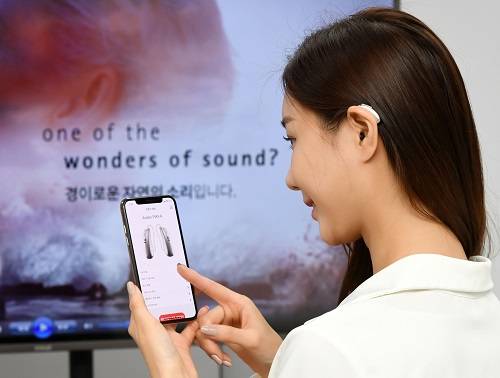 ▲포낙보청기 오데오P를 착용하고 연결된 스마트폰 사운드를 보청기로 직접 청취하는 모습 / 사진=포낙보청기