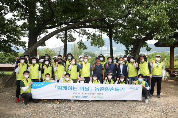 ▲전용범 NH농협생명 경영기획부문 부사장(둘째 줄 왼쪽 여섯 번째), 마을이장, 그리고 임직원이 농촌일손돕기를 기념해 사진을 촬영하고 있다. / 사진=NH농협생명