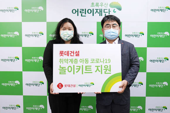 ▲한정호 롯데건설 상무(오른쪽)와 최운정 초록우산어린이재단 본부장이 서울지역 아동을 위한 '놀이 키트' 전달식에서 기념촬영을 하고 있다 / 사진=롯데건설