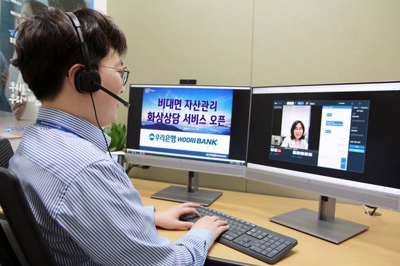 ▲우리은행 직원이 비대면 자산관리 화상상담 서비스를 시연하고 있다. / 사진=우리은행