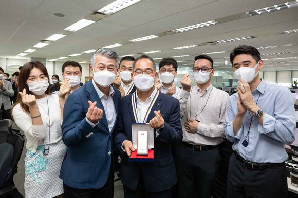 ▲창립 67주년 행사에서 장세욱 동국제강 부회장(가운데에서 왼쪽)과 25년 장기근속상을 수상한 김의진 동국제강 봉형강원료구매팀장(가운데)이 팀원들과 함께 기념사진을 촬영하고 있다 / 사진=동국제강