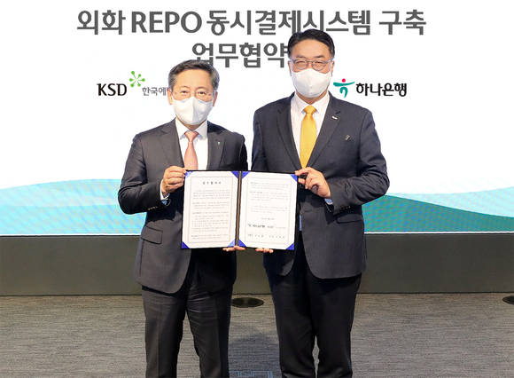 ▲하나은행은 지난 29일 한국예탁결제원과 외화 Repo 동시결제 시스템구축 을 위한 업무협약을 체결했다. 업무 협약식에 참석한 박성호 하나은행장(왼쪽)과 이명호 한국예탁결제원 사장이 기념촬영을 하고 있다. / 사진=하나은행
