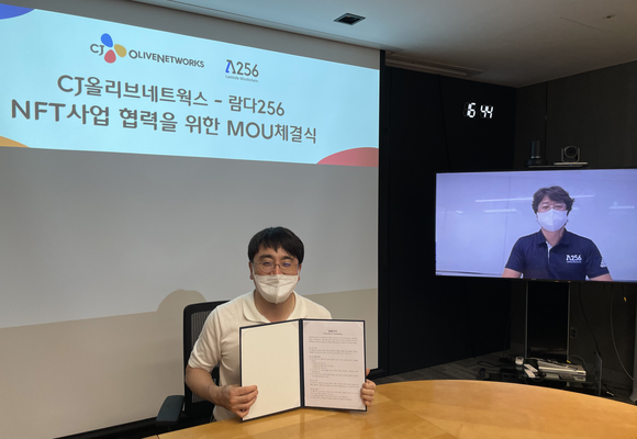 ▲차인혁 CJ올리브네트웍스 대표(왼쪽)와 박재현 람다256 대표(화면속)가 비대면으로 국내·외 전략적 NFT 사업협력을 위한 업무협약을 체결한 뒤 기념촬영을 하고 있다. / 사진=CJ올리브네트웍스