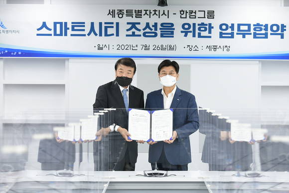 ▲김상철 한컴그룹 회장(왼쪽)과 이춘희 세종시장이 지난 26일 세종시청 집현실에서 스마트시티 조성을 위한 업무협약을 체결한 뒤 기념촬영을 하고 있다. / 사진=한컴그룹