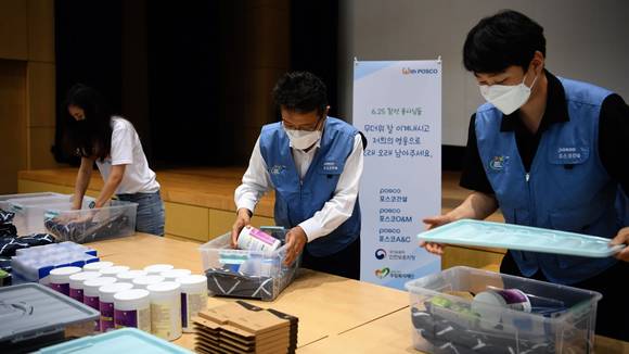 ▲한성희 포스코건설 대표(가운데)가 임직원들과 함께 6.25 참전 유공자를 위한 폭염 피해방지 키트를 제작하고 있다. / 사진=포스코건설