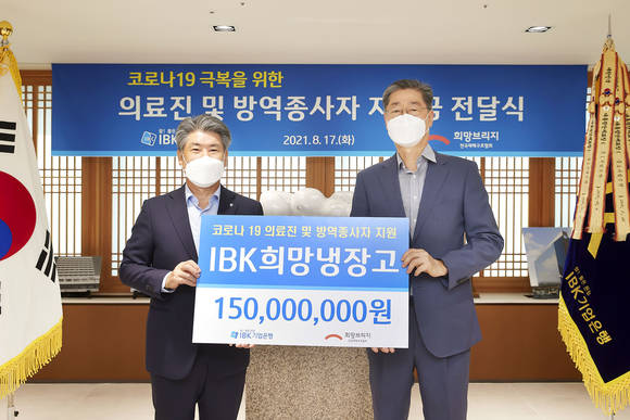 ▲윤종원 기업은행장(왼쪽)과 송필호 희망브리지 전국재해구호협회장이 후원금 전달식을 마치고 기념촬영을 하고 있다. / 사진=IBK기업은행