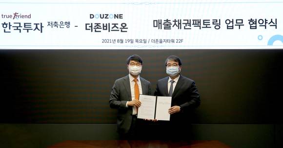 ▲김용우 더존비즈온 대표(오른쪽)와 권종로 한국투자저축은행 대표가 ‘WEHAGO 기반 매출채권팩토링 사업’에 관한 업무협약을 체결한 뒤 기념촬영을 하고 있다. / 사진=더존비즈온