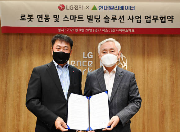 ▲LG전자가 현대엘리베이터와 손잡고 로봇 연동 및 스마트빌딩솔루션 사업에 박차를 가한다. LG전자 BS사업본부장 권순황 사장(왼쪽)과 현대엘리베이터 송승봉 대표가 업무협약식에서 기념촬영을 하고 있다. / 사진=LG전자