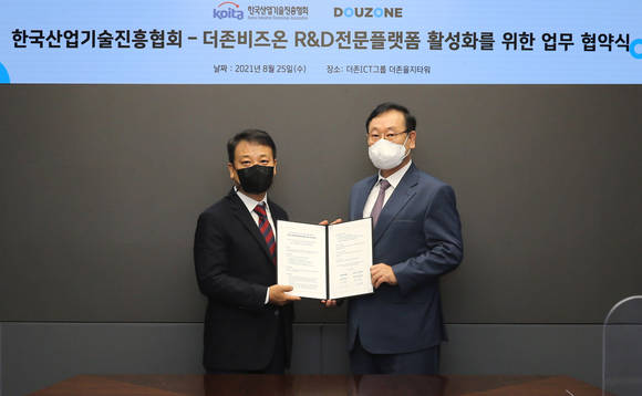 ▲이강수 더존비즈온 사장(오른쪽)과 마창환 한국산업기술진흥협회 상임부회장이 ‘R&D 전문플랫폼 활성화를 위한 업무협약’을 체결한 뒤 기념촬영을 하고 있다. / 사진=더존비즈온