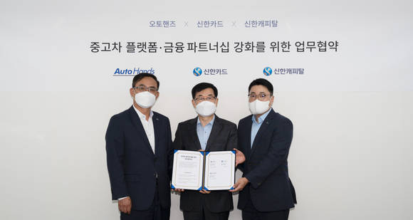▲(왼쪽부터) 최재훈 신한카드 멀티파이낸스그룹장, 강귀호 오토핸즈 대표, 정상훈 신한캐피탈 SI금융본부장이 중고차 플랫폼·금융 파트너십 강화를 위한 업무협약을 체결한 뒤 기념촬영을 하고 있다. / 사진=신한금융그룹