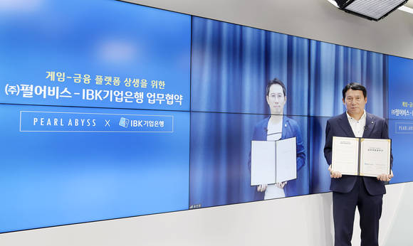 ▲김재홍 IBK기업은행 개인고객‧카드사업그룹 부행장(오른쪽)과 김경만 펄어비스 최고사업책임자가 비대면 업무협약식을 마치고 기념촬영을 하고 있다. / 사진=IBK기업은행