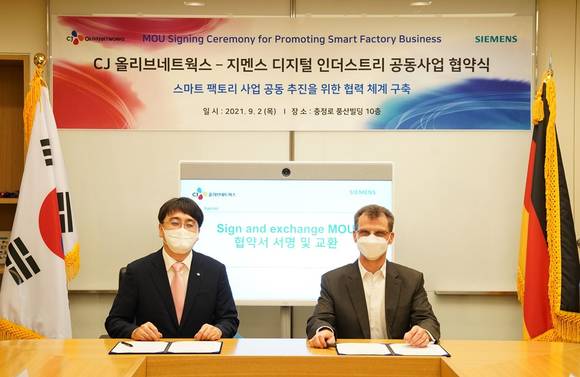 ▲차인혁 CJ올리브네트웍스 대표(왼쪽)와 토마스 슈미드 한국지멘스 디지털 인더스트리 부문 대표가 지난 2일 서울 충정로 한국지멘스 본사에서 열린 전략적 제휴 업무협약을 체결한 뒤 기념촬영을 하고 있다. / 사진=CJ올리브네트웍스