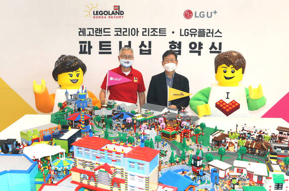 ▲황현식 LG유플러스 사장(오른쪽)과 김영필 레고랜드 코리아 리조트 사장이 독점 제휴를 체결하고 레고 브릭으로 만든 레고랜드 조감도 모형을 보며 기념촬영을 하고 있다. / 사진=LG유플러스