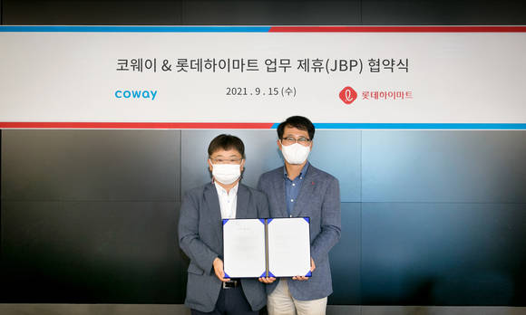 ▲이지훈 코웨이 2사업본부장(왼쪽)과 맹중오 롯데하이마트 상품본부장이 서울 구로구 지타워에서 전략적 비즈니스 파트너십을 맺고 기념촬영을 하고 있다. / 사진=코웨이