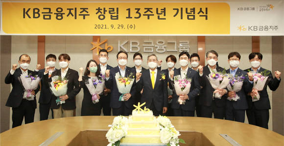 ▲윤종규 회장(왼쪽 여덟번째)이 KB금융지주 창립 13주년 기념식에서 장기근속직원들에게 감사패를 전달하고 기념촬영을 하고 있다. / 사진=KB금융지주