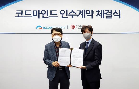 ▲이득춘 이글루시큐리티 대표(왼쪽)와 신승철 코드마인드 대표가 서울 문정동 이글루시큐리티 본사에서 인수 계약을 체결한 뒤 기념촬영을 하고 있다. / 사진=이글루시큐리티