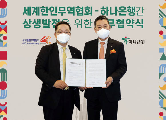 ▲이호성 하나은행 중앙영업그룹 총괄부행장(왼쪽)과 하용화 세계한인무역협회 회장이 협약서를 들고 기념촬영을 하고 있다. / 사진=하나은행