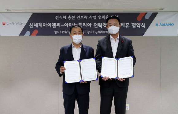 ▲손정현 신세계아이앤씨 대표(오른쪽)와 전명진 아마노코리아 대표가 지난 21일 서울 중구 신세계아이앤씨 본사에서 전기차 충전 인프라 사업을 위한 업무협약을 체결한 뒤 기념촬영을 하고 있다. / 사진=신세계아이앤씨