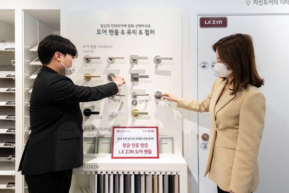 ▲서울 양천구에 위치한 'LX지인 인테리어 지인스퀘어 목동'에서 고객이 'LX지인 도어' 제품의 핸들(손잡이)를 살펴보고 있다. / 사진=LX하우시스