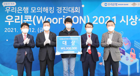 ▲(왼쪽부터)김영기 금융보안원장, 권광석 우리은행장, 대상 수상자, 박춘식 아주대학교 교수, 고정현 우리은행 정보보호그룹장이 ‘모의해킹 경진대회 WooriCON’ 시상식에서 기념 촬영을 하고 있다. / 사진=우리은행